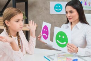Psicóloga infantil atendiendo a un niño en sesión de terapia